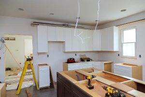 In a set of furniture under construction, white kitchen wooden cabinets were installed with a home improvement view